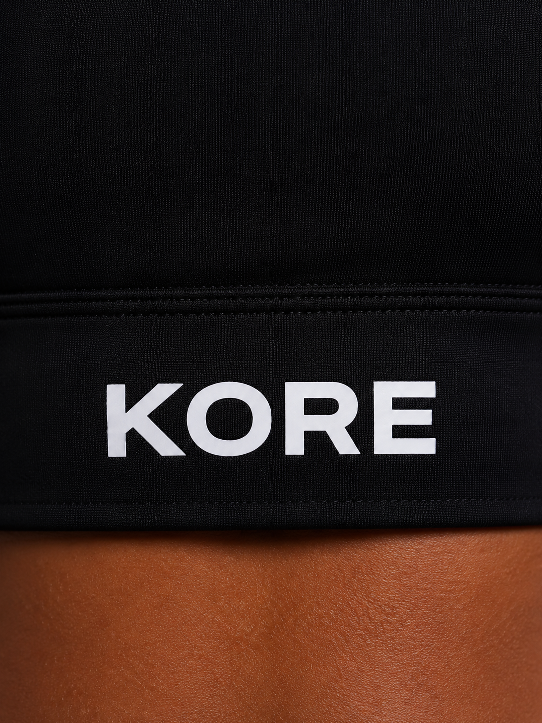 KORE Sculpt Bra — close-up of the back underband with crisp centered K. icon and premium fabric texture